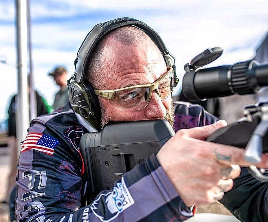 male holding gun wearing Grunt Tactical Sport Sunglasses with black frame and black lenses by Epoch Eyewear